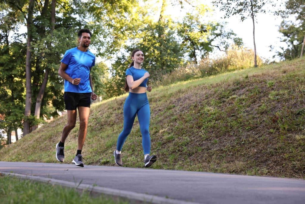 Un jeune couple pratique la course à pied en plein air