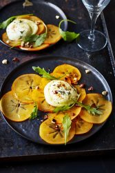 Carpaccio de kaki, roquette, noisettes et chèvre chaud